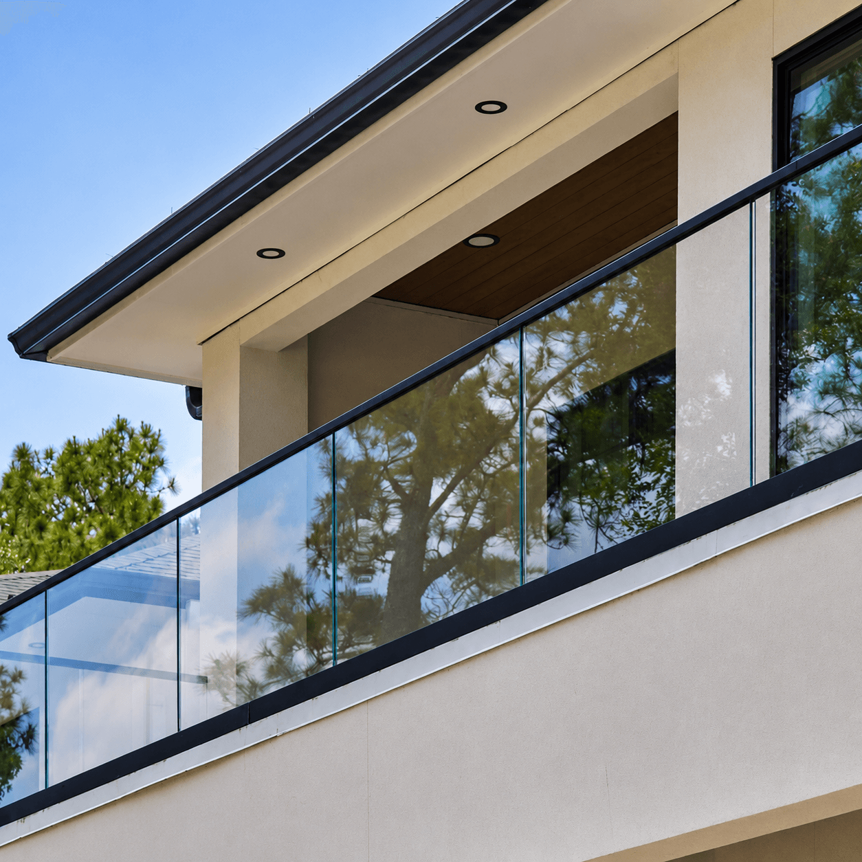 Continuous glass balcony railing with a slim aluminium base channel